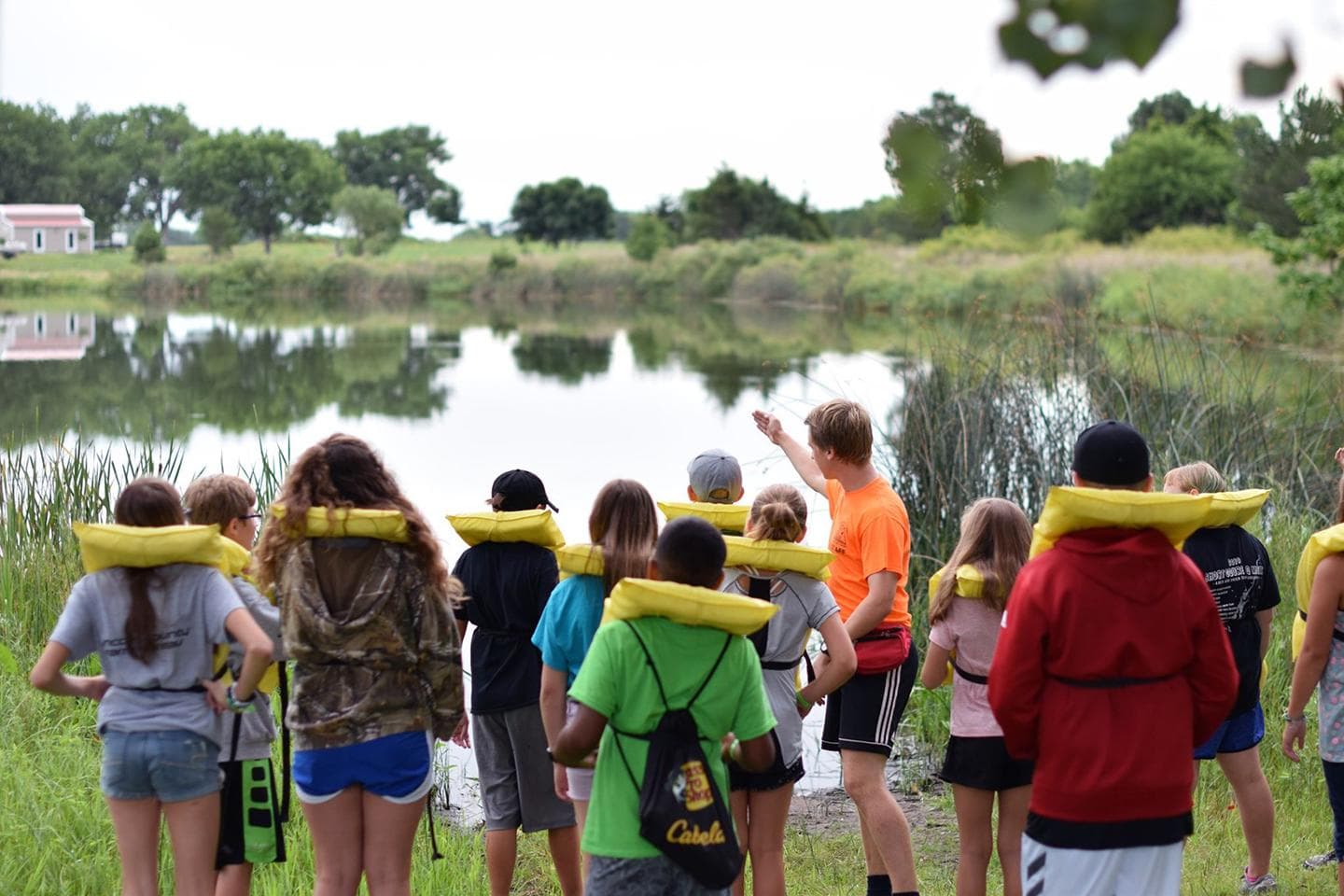 Adult teaching youth at camp.