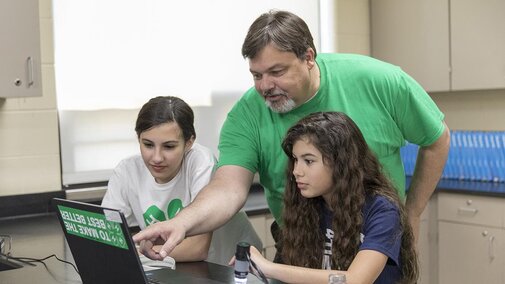 Adult helping youth with STEM project.