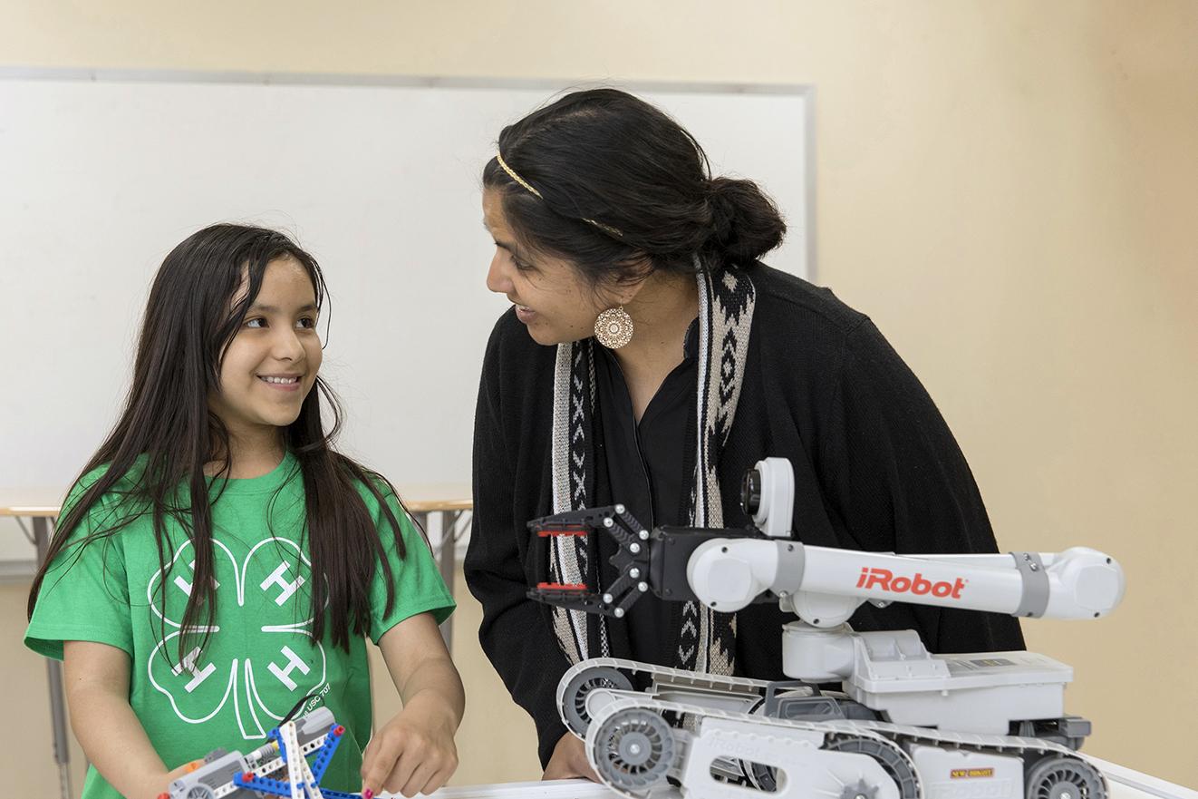 adult leader helps girl with robotics project