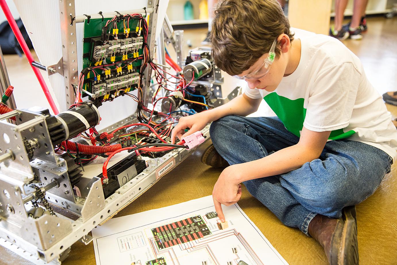child reads instructions while putting together large robot